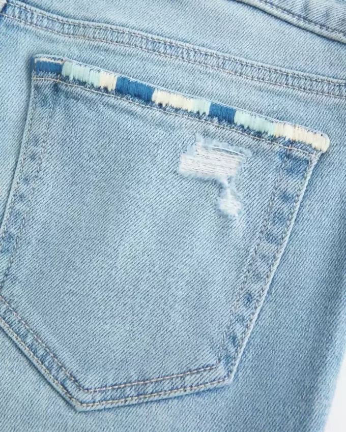 Jeansy z niskim stanem, rozdarciami i lekkim spraniem, z haftowanym krojem Bootcut