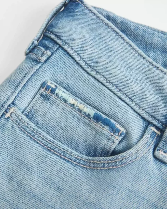 Jeansy z niskim stanem, rozdarciami i lekkim spraniem, z haftowanym krojem Bootcut