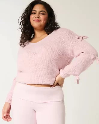 Sweter z aplikacją z kokardą odsłaniającą ramiona