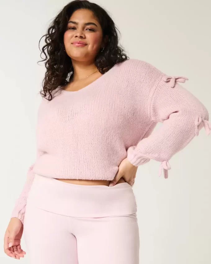 Sweter z aplikacją z kokardą odsłaniającą ramiona